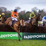 Horses jumping a fence in the Dublin Racing Festival at Leopardstown