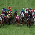 Grand National horses jumping a fence at Aintree