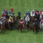 Grand National horses jumping a fence at Aintree